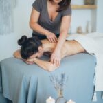 woman lying on bed while having a massage