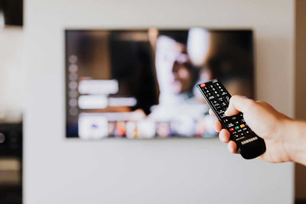 person pressing the button of a remote control