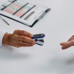 close up of doctor putting a fingertip pulse oximeter on a patients finger