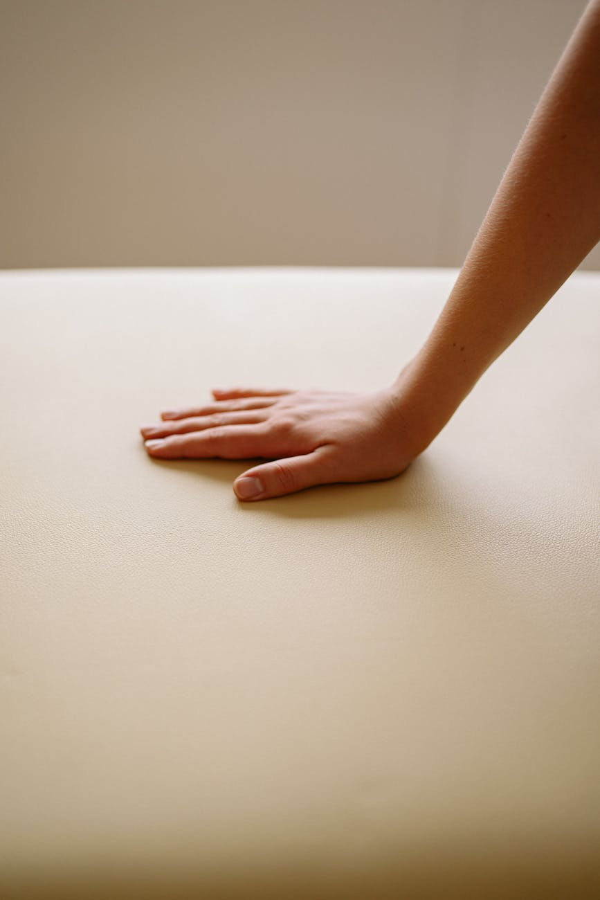 a person s hand on a leather surface